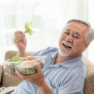 Patient in Phoenix enjoying a meal with new dentures