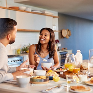 Couple smiling while enjoying meal at home
