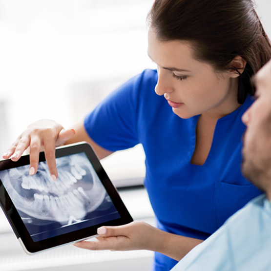 Male patient listening as dentist shows him X-rays 