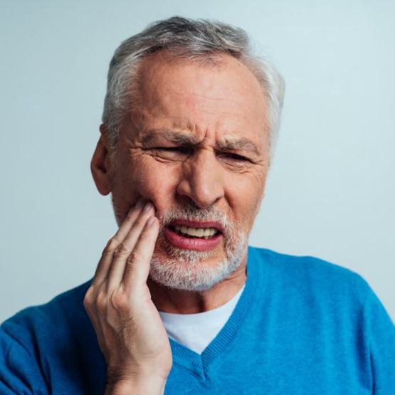 Man rubbing his jaw in pain