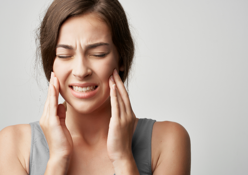 Woman holding face in pain